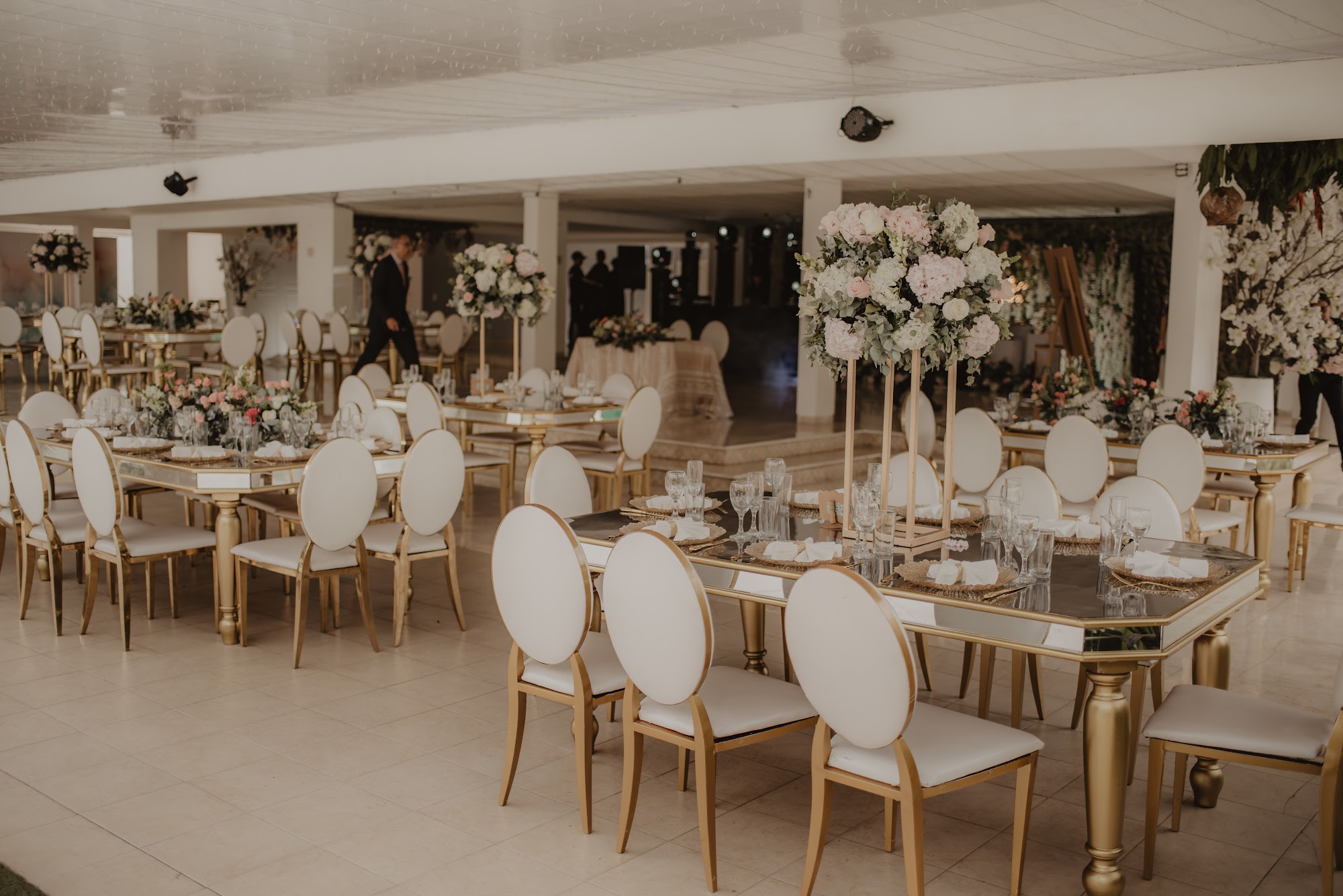 Salón blanco con mesas y sillas doradas